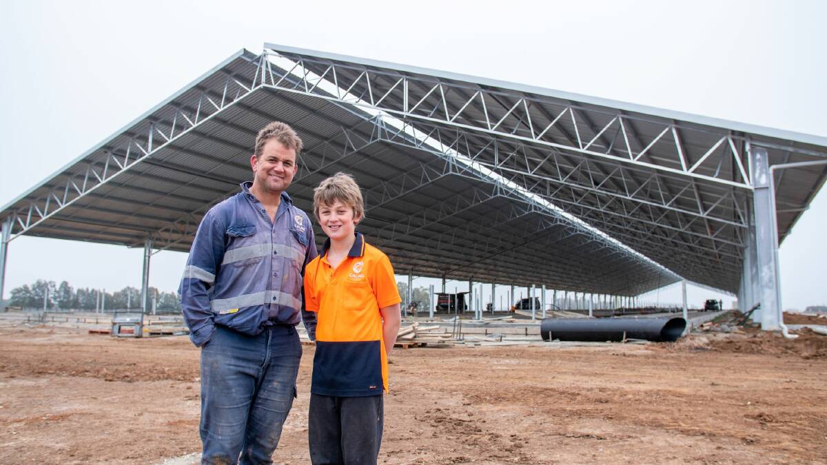 Managing risk: Dairy farmer Jade Clymo with his son Fynn and their new Entegra barn. Picture: Supplied