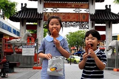 Delicious drumsticks ... Thanh Nguyen, 6, and her brother Tim, 3, enjoy a Red Lea takeaway at Cabramatta yesterday. Photo: Edwina Pickles