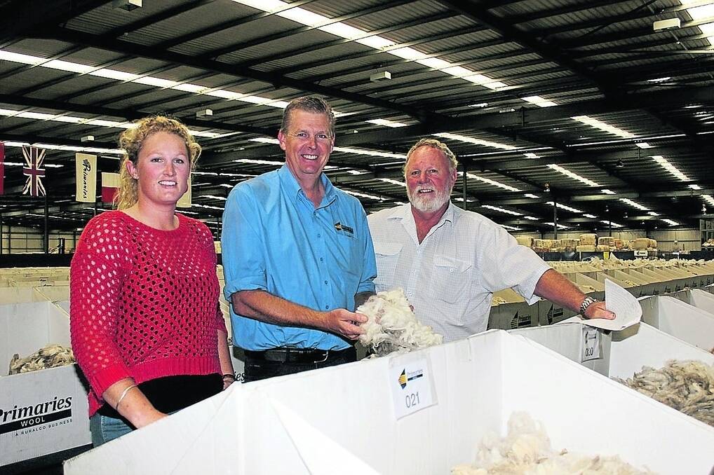 Primaries Mt Barker representative Steve Squires (centre) shows Amy Schlueter and her father Ken, HG Schlueter &amp; Co, Tambellup, the samples of their wool on display on the show floor.