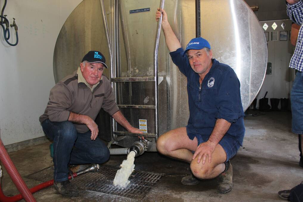 Dumped Harvey dairy farmer Graham Manning (left) and WAFarmers dairy council president Michael Partridge letting Mr Manning's grade one milk go down the drain on Tuesday.