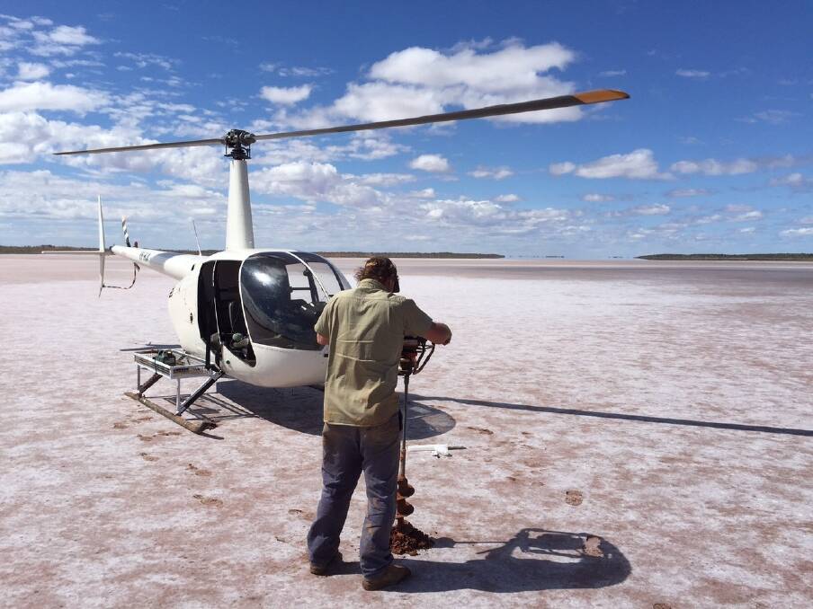 Drilling through the salt crust of a dry lake in the Little Sandy Desert to establish brine depth.