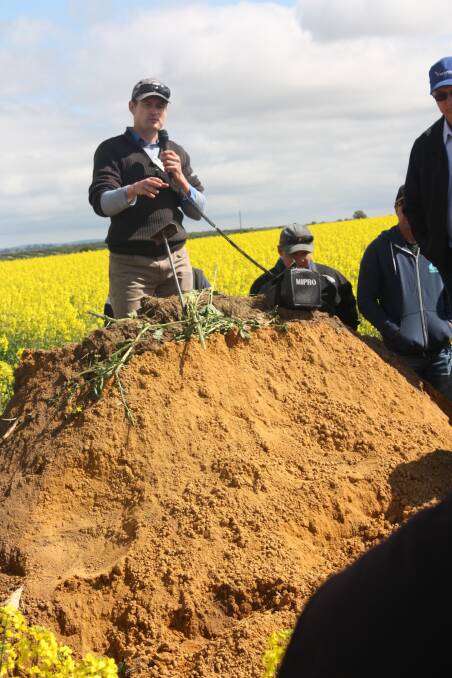 DPIRD research officer Wayne Parker speaks about deep ripping strategies standing on a sand pit mound on Bolgart farmer Trevor Syme's property.